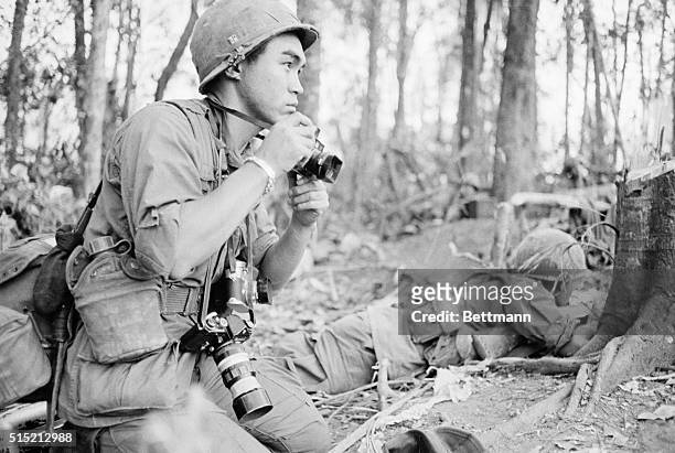 Armed with a battery of cameras, Pulitzer Prize-winning Japanese war photographer Kyoichi Sawada of UPI, covers the battle of Hill 875 in the...
