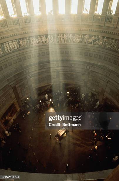 Sunlight streams through the columns of the The Rotunda of the U.S. Capitol, onto the coffin of the late President John F. Kennedy. The body of the...