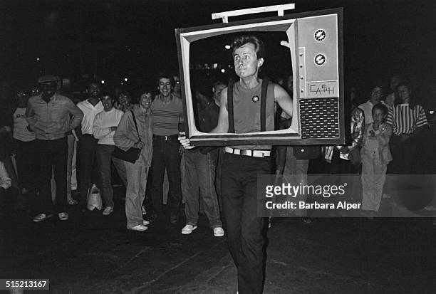 Man walking with a cut-out of a TV set during a Halloween parade in Greenwich Village, New York City, 31st October 1981.