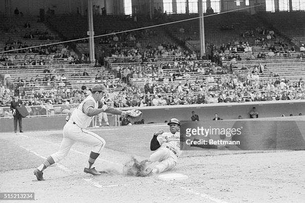 Cleveland, OH- Frank Robinson of Baltimore had to slide into first base to escape the glove of Cleveland first baseman Tony Horton, in seventh inning...
