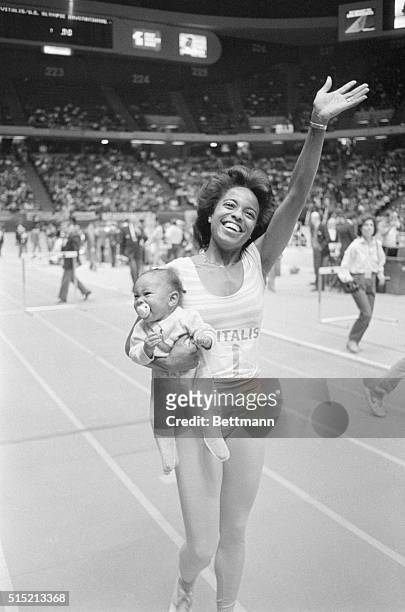 East Rutherford, New Jersey- Evelyn Ashford holds her eight-month old baby daughter Raina Ashley Washington while taking her victory lap after...