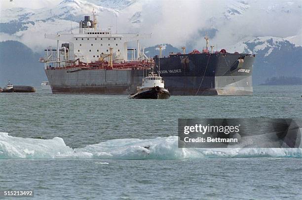 Prince William Sound, AK- The tanker Exxon Valdez is pulled across Prince William Sound by a tug boat, past floating ice, after having been freed...