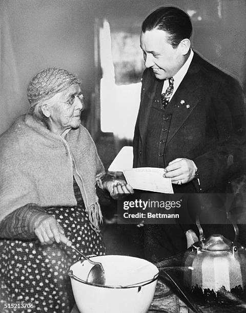 Bradley, MI - In her home here Mrs. Sarah Issac receives her old age pension check from the State of Michicagn as it is tendered her by Dr. Philip A....