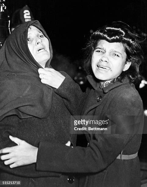 Cried when I took this picture," says Weegee. Mother and daughter weep and look up hopelessly as another daughter and her young baby are burning to...