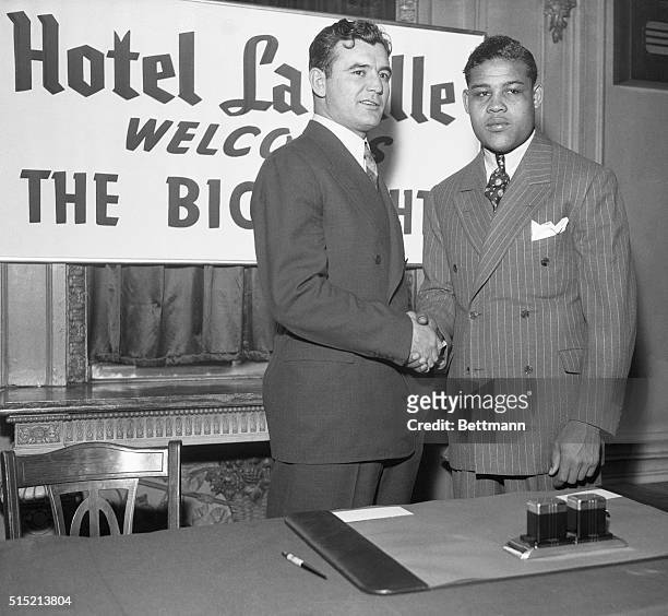 Chicago, IL- James Braddock , heavyweight champion of the world, and Joe Louis, the challenger, are shown shaking hands after they had signed for...
