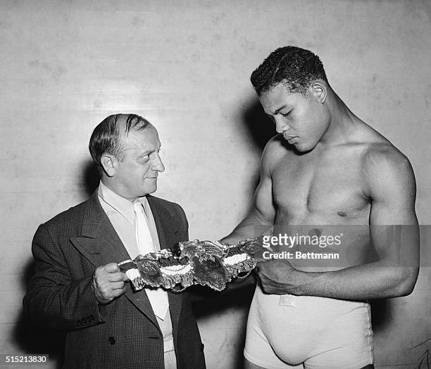 Pompton Lakes, NJ- Joe Louis, world heavyweight champion, was presented with a belt emblematic of the title, at his training camp in Pompton Lakes,...