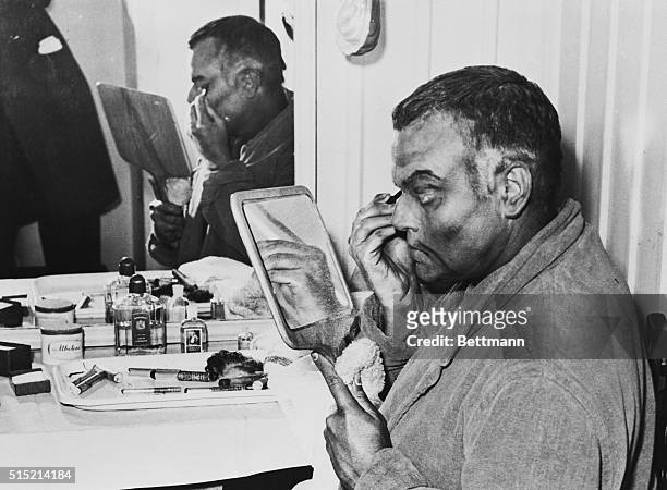 Stage and movie actor Orson Welles puts on stage makeup for his part as Othello in the play Othello by Shakespeare at the St. James Theatre in...