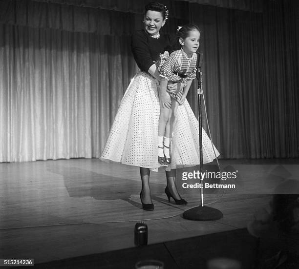 During a performance, Judy Garland holds her daughter up to the microphone to sing Jingle Bells after spotting her in the audience.