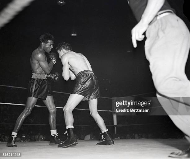 Cleveland, OH:- Sugar Ray Robinson misses with a right to Doyle's head in the 6th round of their fight at the arena Tuesday. Doyle is seen recoiling...