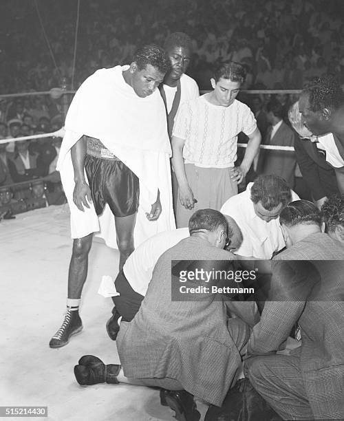 Cleveland, Ohio- Ray Robinson, , looks down at the prostrate figure of Jimmy Doyle as Doctors try to awaken the unconscious fighter. He was carried...