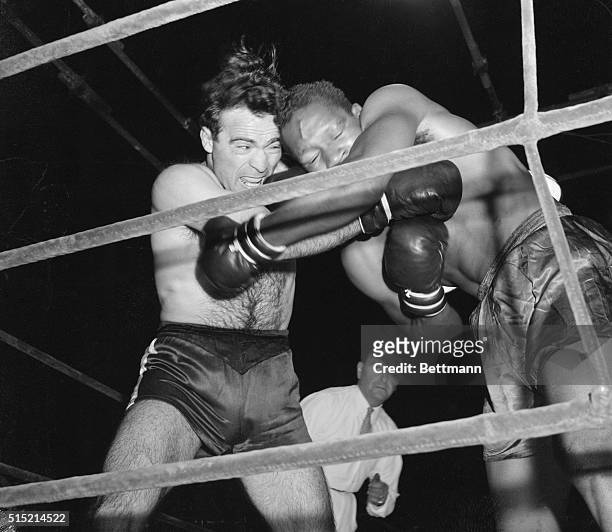 Paris, France-: Marcel Cerdan connects in close-in fighting in the fourth round of ten against Holman Williams of Chicago. The French middleweight...