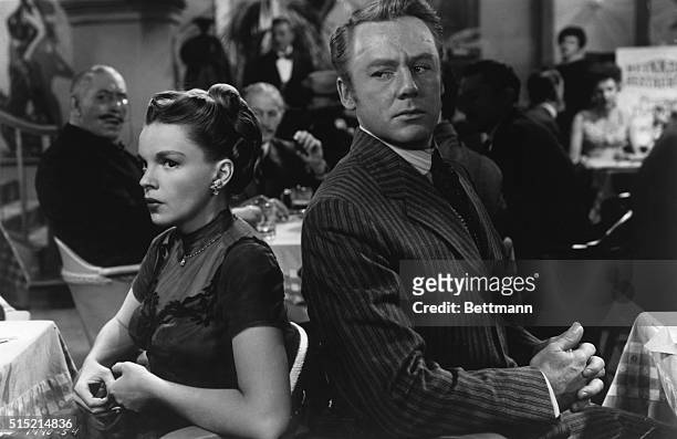 Judy Garland sitting back-to-back with Van Johnson, in a scene from the 1949 MGM technicolor film, "In The Good Old Summertime."