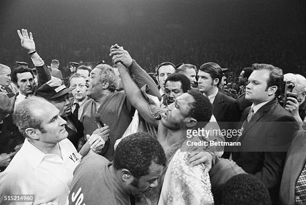 New York, NY-: Yank Durham, manager, holds up the arm of Joe Frazier, who just won a 15-round decision over Cassius Clay for the world heavyweight...