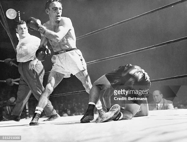 Boston, MA- Challenger Tony Demarco slumps to the canvas after taking a series of crashing lefts and rights from welterweight king Carmen Basilio in...