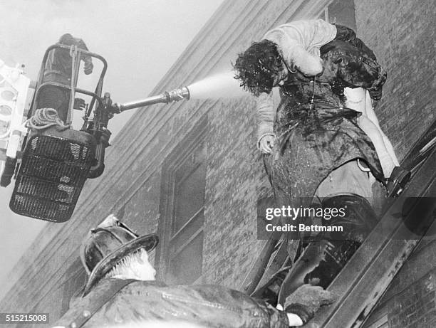 Chicago, IL- A fireman carries the body of a student from Our Lady of the Angels parochial school, as a hose pours a stream of water into the burning...