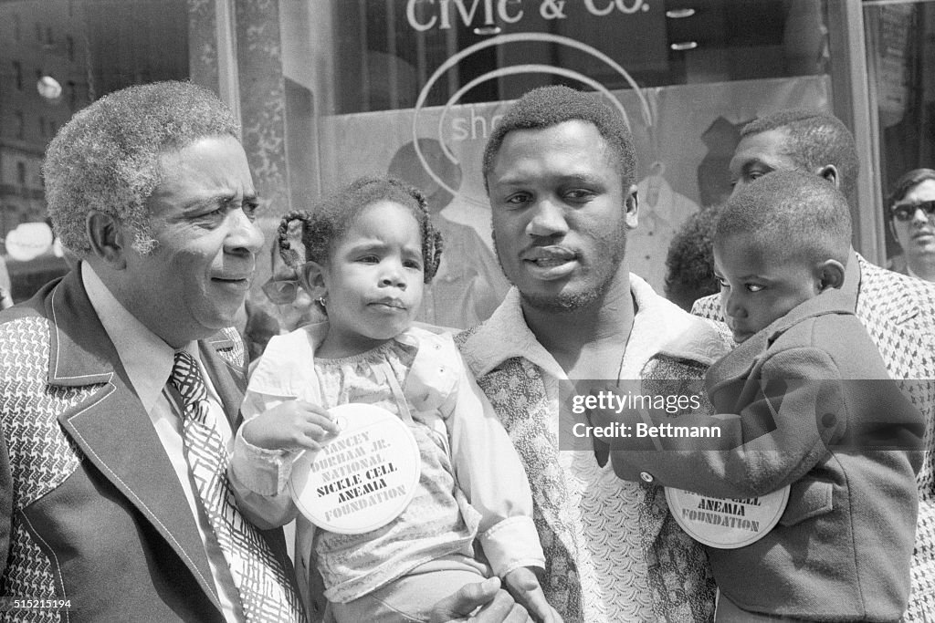 Joe Frazier Holds Two Kids with Sickle Cell