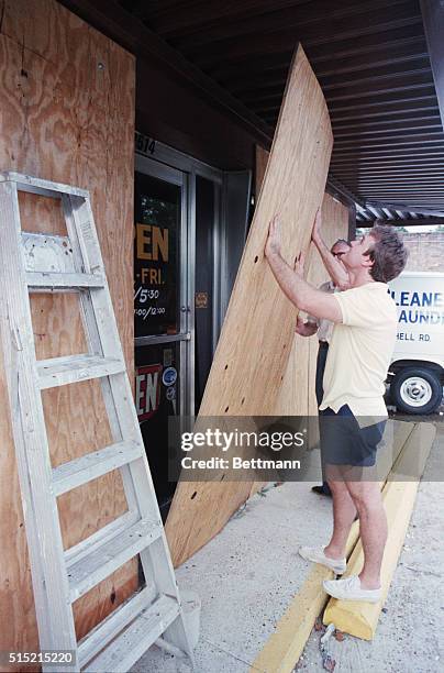 Mobile, Alabama- Leland Waite and his dad Taylor board windows and doors to protect their business, The Waite Cleaing and Laundry Company, from...