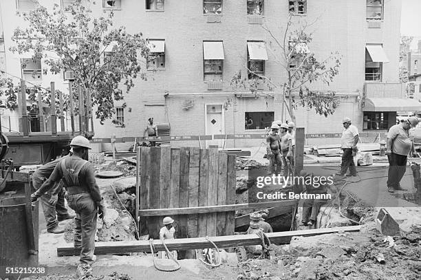 New York, New York- Utility workers repair the damage sone by a steam pipe that burst Saturday afternoon blowing a twenty-foot hole in the street and...