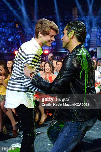 Actor Jace Norman pours a bucket of slime on actor John Stamos during Nickelodeon's 2016 Kids' Choice Awards at The Forum on March 12, 2016 in...