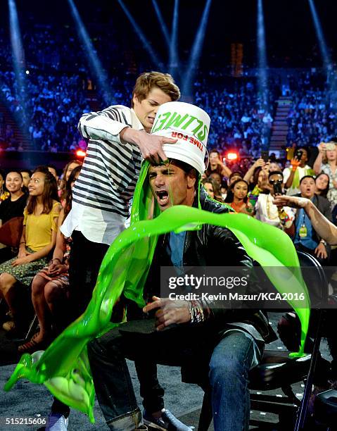 Actor Jace Norman pours a bucket of slime on actor John Stamos during Nickelodeon's 2016 Kids' Choice Awards at The Forum on March 12, 2016 in...