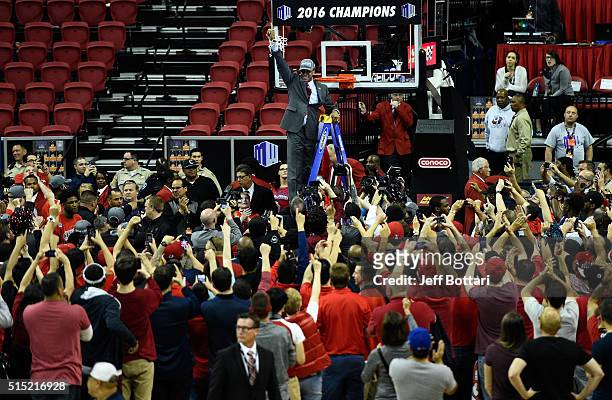 Head coach Rodney Terry of the Fresno State Bulldogs celebrates with fans by cutting down the net after defeating the San Diego State Aztecs 68-63 to...