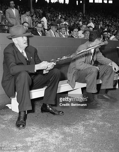 Cleveland, Ohio- Waving a cane carved from a baseball bat in 1897, Cy Young, one of baseball's greats, attends the Cleveland-Detroit opener, 50 years...
