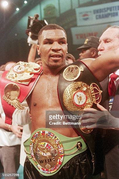Atlantic City, NJ- Unquestionably the heavyweight champion of the world, Mike Tyson shows off his 3 championship belts- the WBC, WBA, and IBF -after...