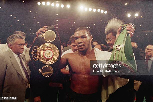 Las Vegas, NVMike Tyson holds up the heavyweight belts for the WBA and WBC championships. Tyson won a unanimous decision over Tony Tucker.