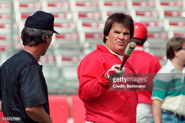 Plant City, FL- Reds manager Pete Rose points his bat at a group of photographers prior to their game against the Pirates and has some...