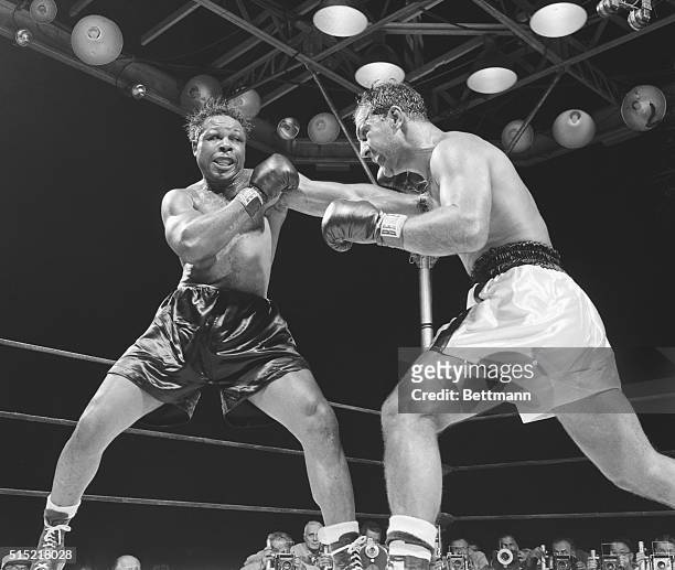 Light heavyweight champion Archie Moore lands a hard left during the fifth round of his bout against heavyweight champion Rocky Marciano at Yankee...