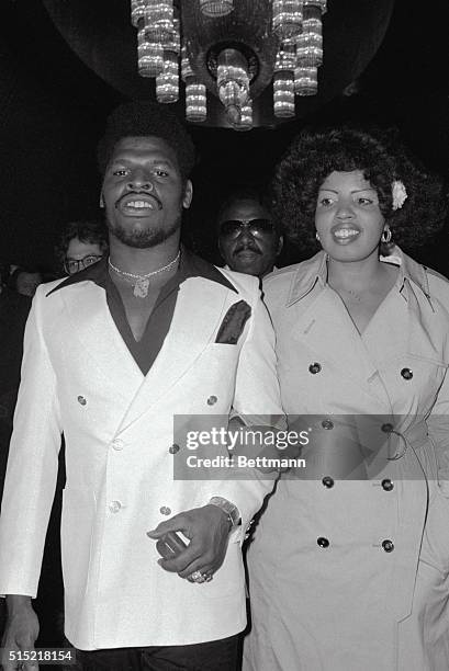 New York, New York- World Heavyweight Champ Leon Spinks arrives at the Americana Hotel, with his wife, Nova, to sign for a rematch with Muhammad Ali....