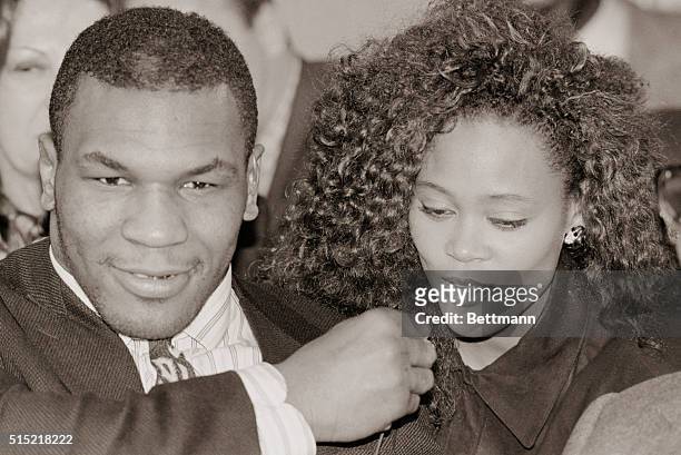 New York, New York- Robin Givens, Mike Tyson's bride of 2 days, covers his mouth with her hand during a satellite broadcast to Japan from NYC after...