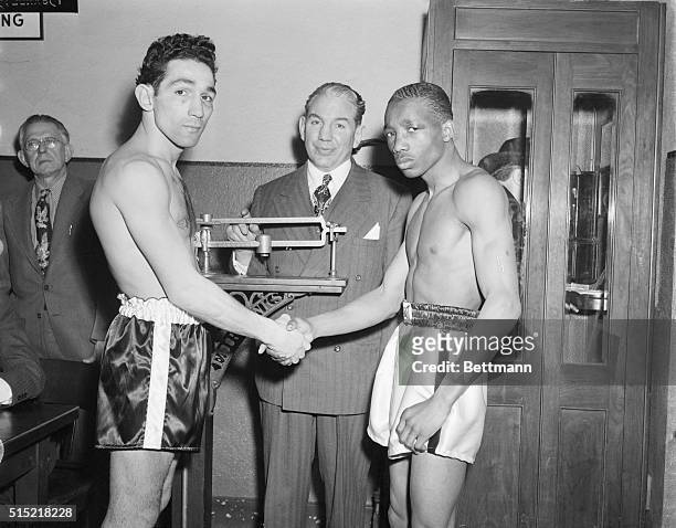 New York, New York- Champion Sandy Saddler and Willie Pep shake hands at weigh-in for their return featherweight title bout at Madison Square Garden....