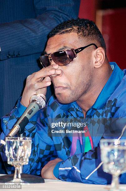 New York, NY- Ex-heavyweight champion Mike Tyson is shown holding his nose at a press conference here 2/13. Tyson, who lost his title to James...