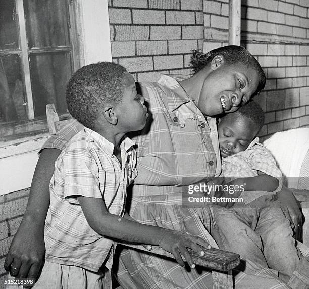 Lumberton, MS- Mrs. Eliza Parker , mother of Charlie Parker, weeps bitterly as she holds her young son "Peanut" who sleeps soundly. At right is...
