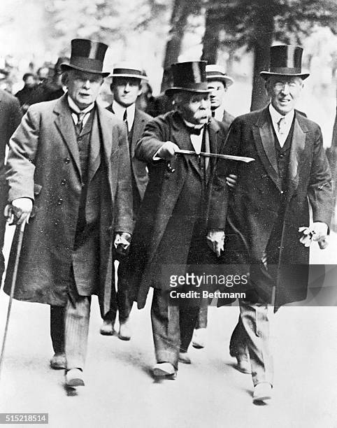 British Prime Minister Lloyd George, French Premier Georges Clemenceau, and U.S. President Woodrow Wilson walk together in Paris during negotiations...