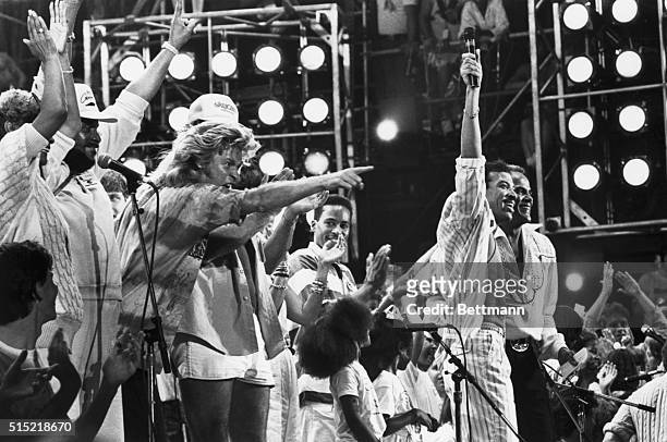 Lionel Richie and Harry Belafonte are joined by other performers at the Live Aid concert in Philadelphia as they all sing the concert-ending song of...
