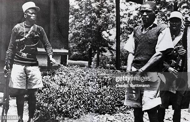 Nairobi, Kenya- Jomo Kenyatta, convicted leader of the Mau Mau terrorists, is shown following arrest, with his hands tied at the end of a rope held...