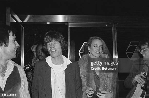 Rock star Mick Jagger and his future wife, model Jerri Hall, arrive at Studio 54 to attend an "Oscar" party at the disco club.