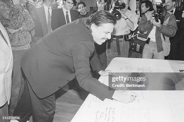 New York, NY-ORIGINAL CAPTION: Artist Peter Max is one of the last signers of "America's Christmas Card to Russia," a gigantic scroll bearing over...