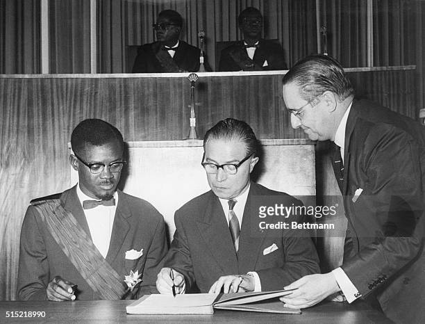 Leopoldville, Congo-Mr. Patrice Lumumba, the Congolese Prime Minister, and Mr. Gaston Eyskens, Belgian Premier, sign the act of independence in the...