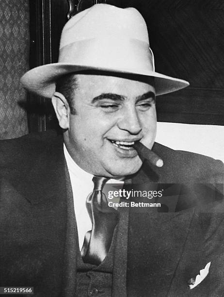 Infamous gangster Al Capone smokes a cigar on the train carrying him to the federal penitentiary in Atlanta where he will start serving an...