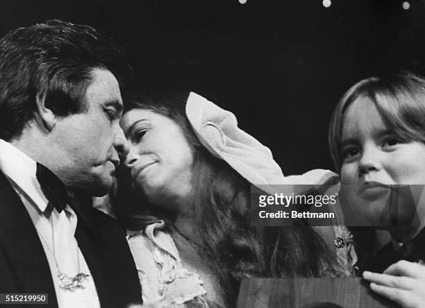 Johnny Cash is kissed by his wife, June Carter, after being inducted into the Country Music Hall of Fame during the Country Music Association's...