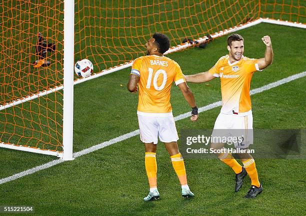 Giles Barnes of and Will Bruin of the Houston Dynamo celebrate a first-half own goal against FC Dallas during their game at BBVA Compass Stadium on...