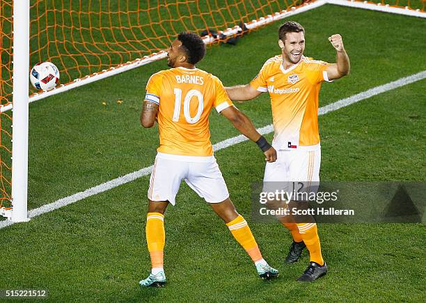 Giles Barnes of and Will Bruin of the Houston Dynamo celebrate a first-half own goal against FC Dallas during their game at BBVA Compass Stadium on...