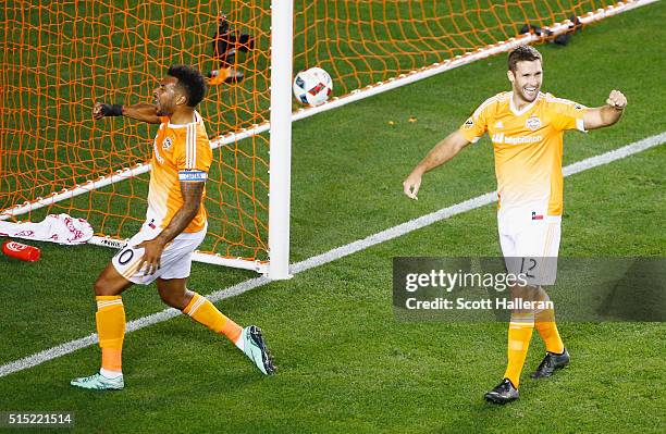 Giles Barnes of and Will Bruin of the Houston Dynamo celebrate a first-half own goal against FC Dallas during their game at BBVA Compass Stadium on...