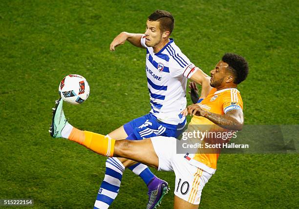Giles Barnes of the Houston Dynamo battles for the ball with Matt Hedges of FC Dallas during their game at BBVA Compass Stadium on March 12, 2016 in...