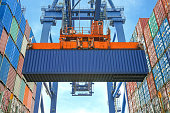 Shore crane loading containers in freight ship