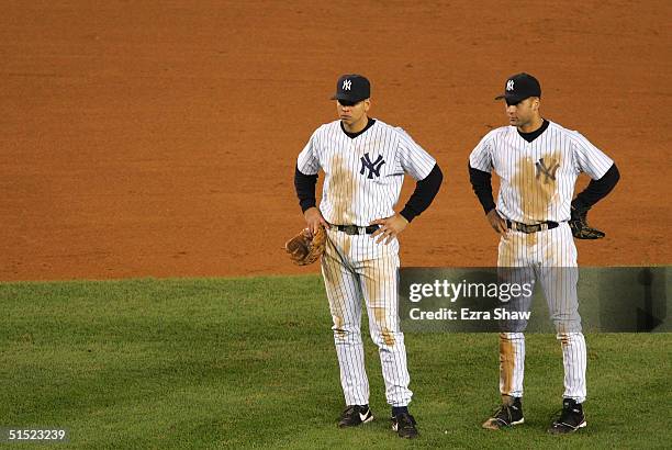 Alex Rodriguez and Derek Jeter of the New York Yankees watch during a pitching change in the seventh inning against the Boston Red Sox during game...