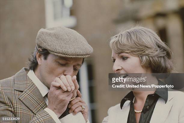 English actor Peter Bowles kisses the hand of actress Penelope Keith in character as Richard DeVere and Audrey fforbes-Hamilton from the television...